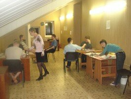 Люди сидят за столами в помещении во время группового занятия